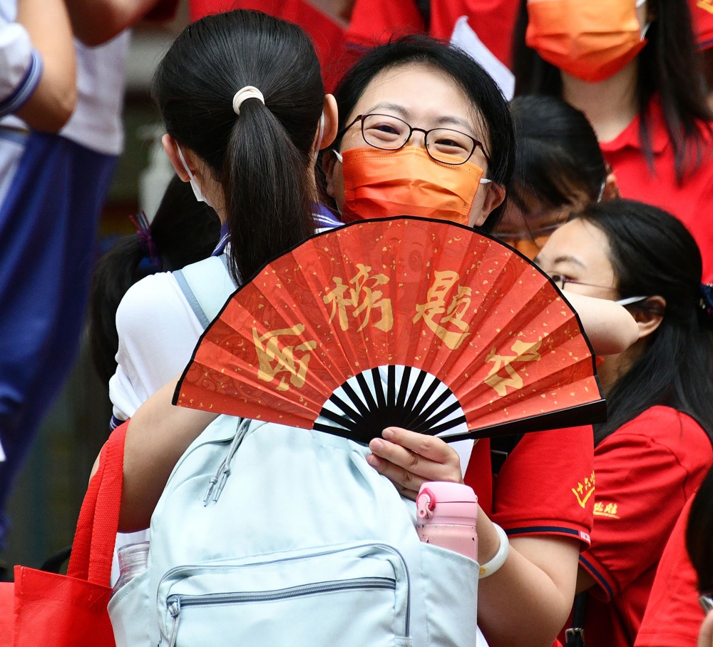 老师的愿望+2022年6月8日，高考的第二天，16中同学入场时，一位女老师手持“金榜题名”为学生加油_01.JPG